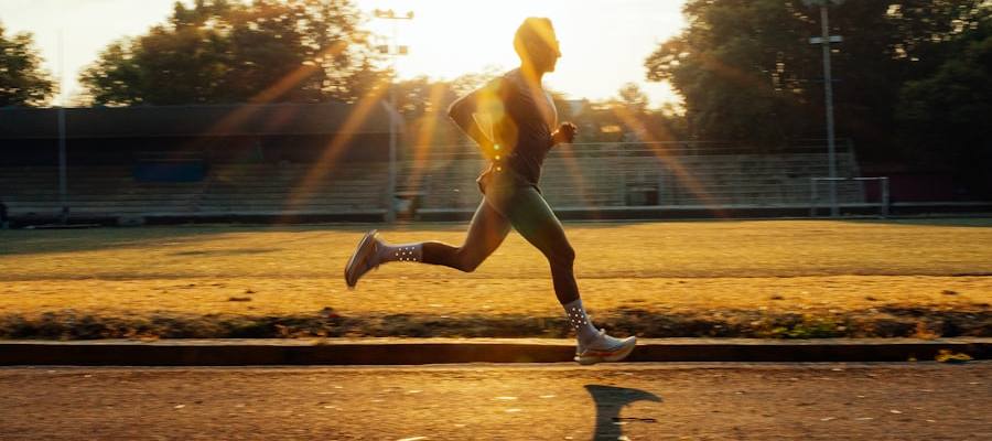 A runner on a track in golden evening light