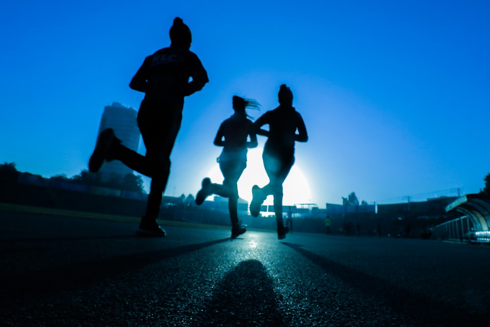 A small group of runners silhouetted against the sunrise